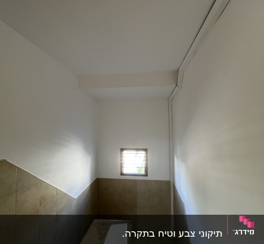 קירות צבועים בלבן במדרגות עם חלון קטן